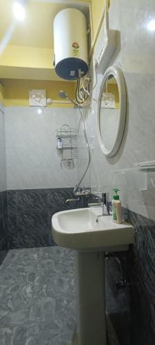 a bathroom with a sink and a mirror at Ang Ds Homestay in Sonāda