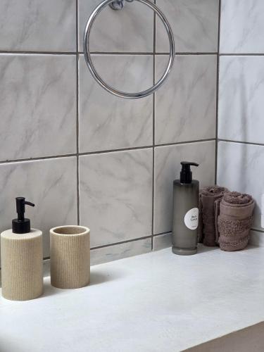 a bathroom with three soap dispensers on a counter at Lithos Home Agia Galini in Agia Galini