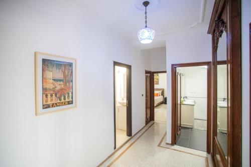 a hallway with white walls and a picture on the wall at Apartamento en Residencia Brooks Iberia in Tangier
