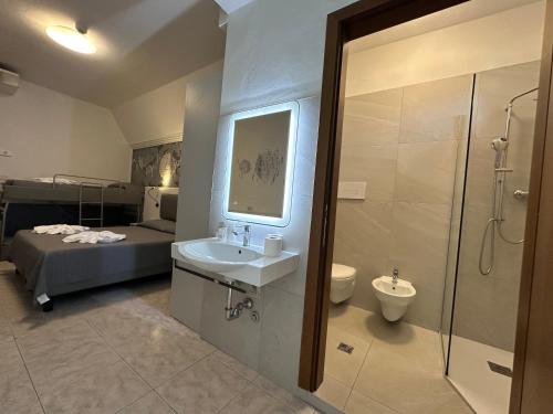 ein Badezimmer mit Waschbecken, Toilette und Bett in der Unterkunft Hotel DOLCEVITA Park & Beach included in Lido di Jesolo