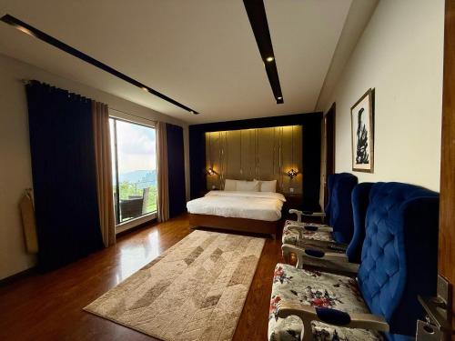 a bedroom with a bed and a blue couch at Tower 92 - Hotel in Ghora