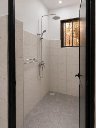 a shower with a glass door in a bathroom at Boma Retreat in Boma la Ngombe