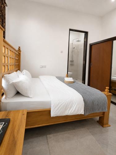 a bedroom with a large white bed and a table at Boma Retreat in Boma la Ngombe