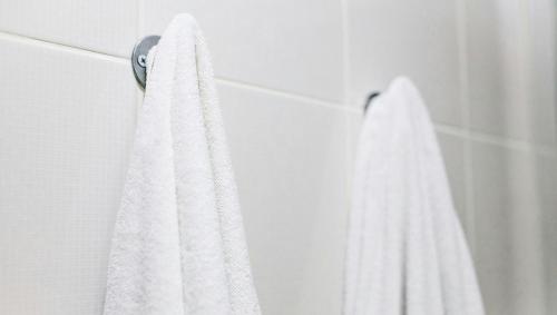 a white towel hanging on a wall in a bathroom at Executive Inn Schulenburg in Schulenburg