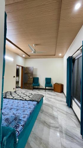 a bedroom with a bed and two blue chairs at 1 Bed Apartment with View in Patriata