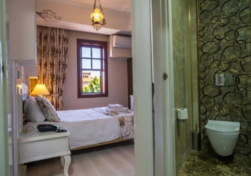 a bedroom with a bed and a window and a bathroom at Kaleiçi Ozkavak Hotel in Antalya