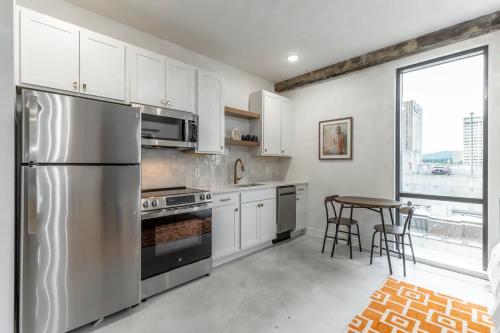 a kitchen with a stainless steel refrigerator and a table at Park Hotel Studio Suite 507 in Chattanooga