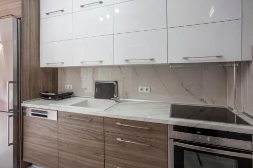 a kitchen with white cabinets and a sink at Villa Olia with private pool in Pefkochori