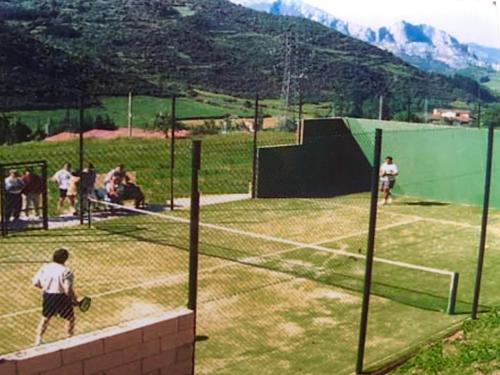 a group of people playing tennis on a tennis court at Apartamentos Alquitara in Potes