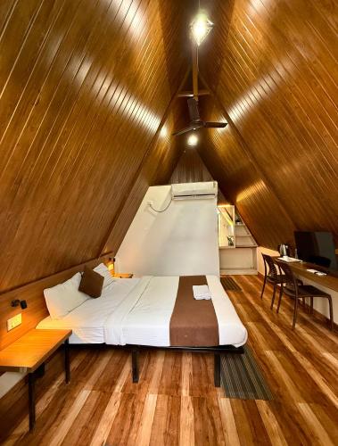 a bedroom with a bed in a wooden ceiling at Urban Villa in Guwahati