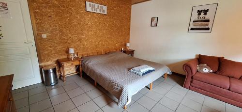 a living room with a bed and a couch at Chez Chou-Vrac & Ciboulette in Durbuy