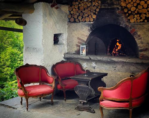 two chairs and a table in front of a fireplace at Stone Oven House in Rorá