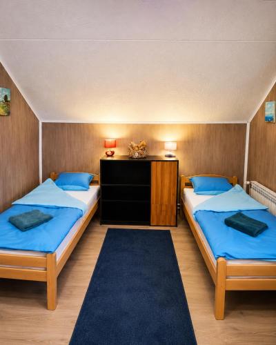 a bedroom with two beds and a table with two lamps at Hostel Suzzzy in Novska