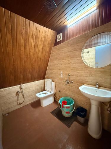 a bathroom with a sink and a toilet and a mirror at Urban Villa in Guwahati