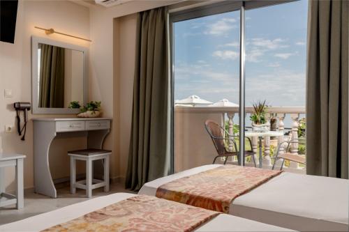 ein Hotelzimmer mit zwei Betten und Balkon in der Unterkunft Anemona Beach Hotel in Argassi