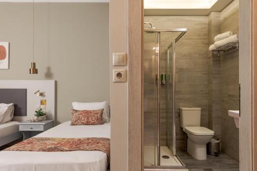 ein Badezimmer mit Dusche, ein Bett und eine Toilette in der Unterkunft Anemona Beach Hotel in Argassi