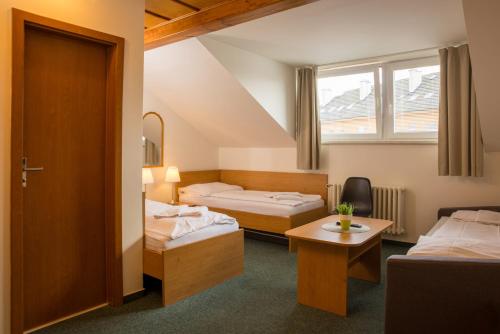 a hotel room with two beds and a window at Hotel Kanarek in Prague