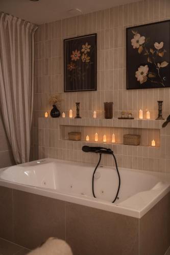 a bath tub in a bathroom with candles on the wall at Apparts Rennes BnB Duhamel in Rennes