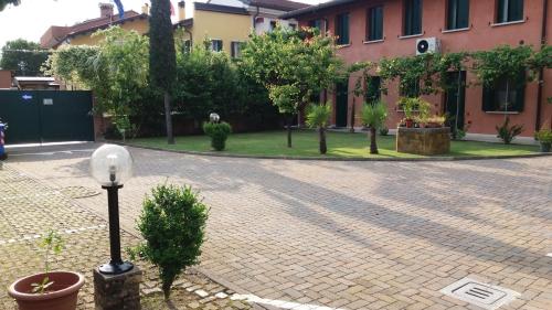 a brick courtyard with a street light and a building at Dreon B&B in Portogruaro