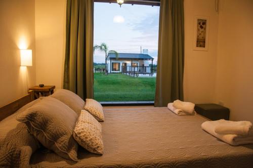 1 dormitorio con 1 cama y ventana grande en Cabañas El Origen en Colón