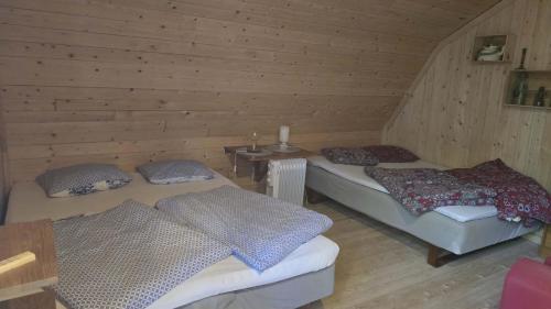 a attic room with two beds and a table at Vinds Våningen in Uddevalla