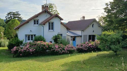 a white house with flowers in the yard at Le chant des roses in Giverny