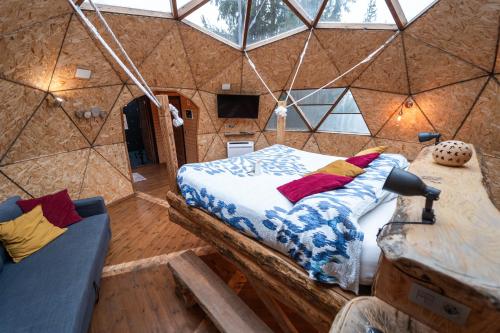 a bedroom in a yurt with a bed and a couch at Xalet De Prades in Prades