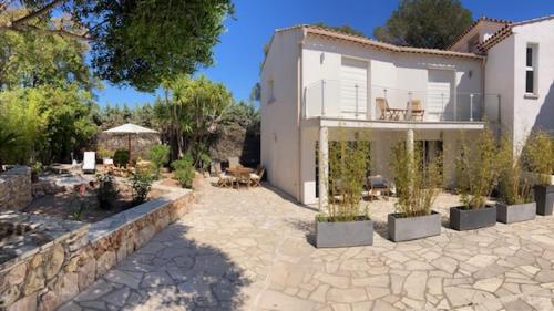 a large white house with a patio in front of it at Villa "LES ALIZES" Côté jardin - Bord de mer in Saint-Raphaël
