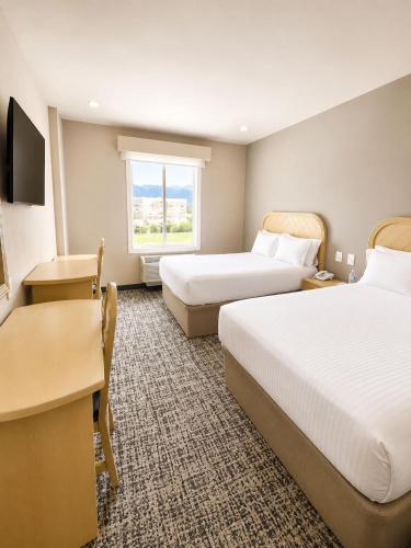 ein Hotelzimmer mit zwei Betten und einem Fenster in der Unterkunft Victoria Inn in Ciudad Victoria