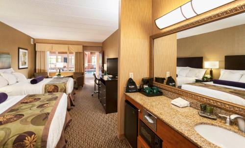 a hotel room with two beds and a sink and a mirror at The Inn on Lake Superior in Duluth
