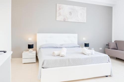a white bedroom with a bed and a couch at Mediterraneum in Sannicola