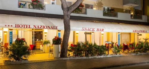 a hotel kuala lumpur with a tree in front of a building at Hotel Nazionale in Lido di Jesolo