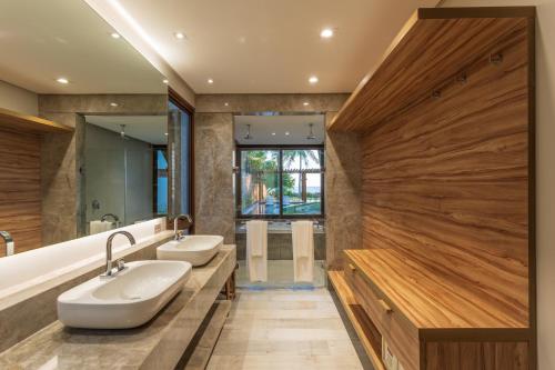 a bathroom with two sinks and a large mirror at Serrambi Resort in Porto De Galinhas