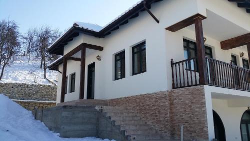 a house with snow on the ground at Pensiunea Agroturistica Cerna, Vaideeni - Polovragi in Vaideeni
