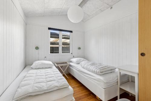 a white room with two beds and a window at Close To The Beach With Outdoor Spa in Slagelse