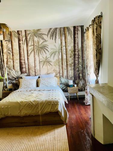 a bedroom with a bed and palm trees mural at Château Lagelouse in Mimbaste