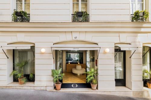 a building with potted plants in front of it at Hôtel Oratio in Paris