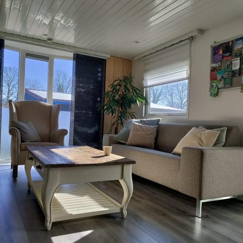 a living room with a couch and a coffee table at Chalet midden in de natuur! in Anloo