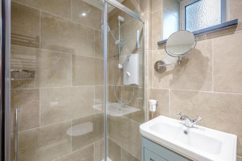 a bathroom with a shower and a sink and a mirror at 3 Bed in Morpeth oc-75083 in Harbottle