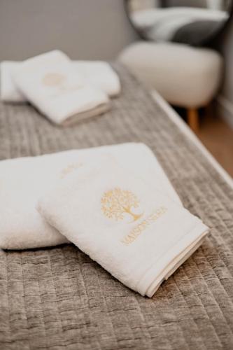 two white towels sitting on a bed at Maison Sidra in Thessaloniki