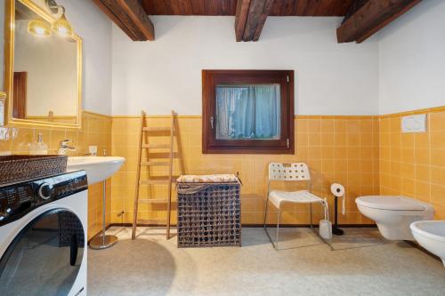 a bathroom with a sink and a toilet and a mirror at Cozy Country Loft Oleandro in Chioggia
