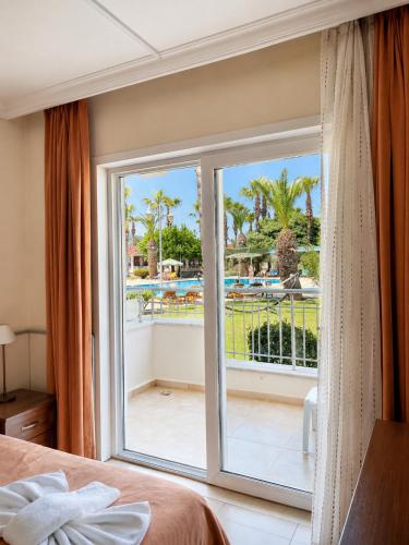 ein Schlafzimmer mit einer großen Glastür, die auf einen Balkon führt in der Unterkunft Hotel Keskin in Dalyan
