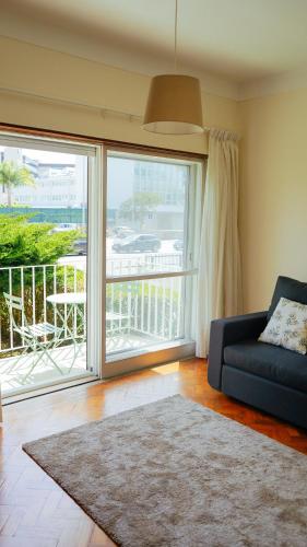 a living room with a couch and a large window at City Centre Cozy Apartment in Porto