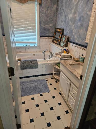 ein Badezimmer mit Badewanne und Waschbecken in der Unterkunft Gloucester House with Sea View in Gloucester