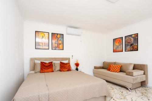 a white bedroom with a bed and a couch at Villa Kaplan Verde in Stolac