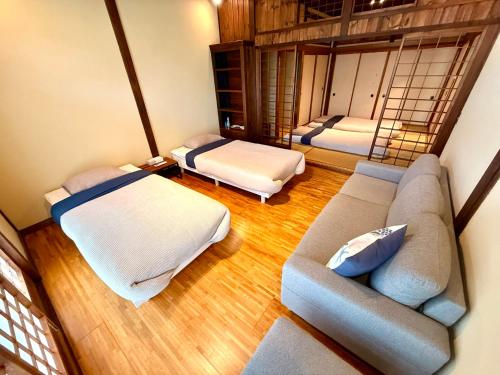 a living room with two beds and a couch at SADO Stay 02 金山京町一軒家貸し切り in Sado