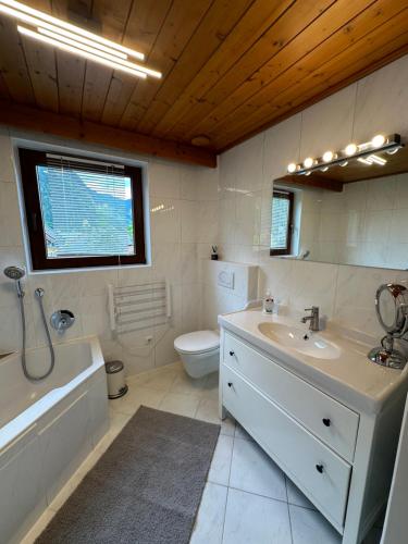 a bathroom with a tub and a sink and a toilet at Boardwalk center in Mayrhofen