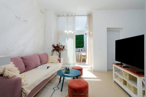 a living room with a couch and a tv at Sunstay Arroyo House Velez in Vélez-Málaga