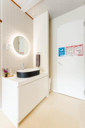 a bathroom with a sink and a mirror at Maison Atago201 in Fukuoka