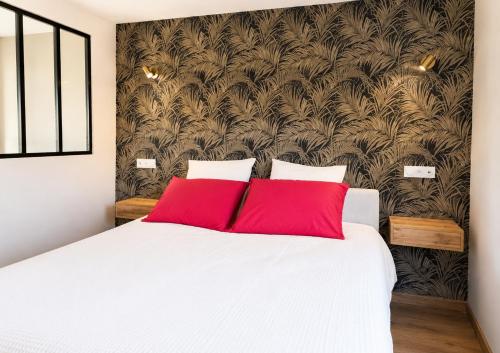 a bedroom with a large white bed with red pillows at La Part'Thé in Crouy-sur-Cosson